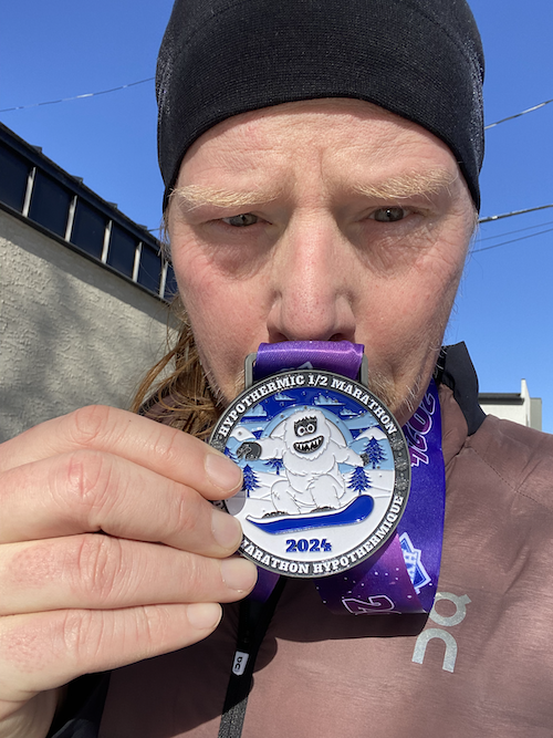 Author posting with a half-marathon race medal